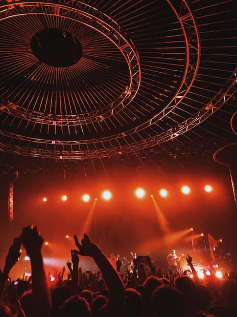 Photo d'un public en concert sous un éclairage de scéne rougeâtre