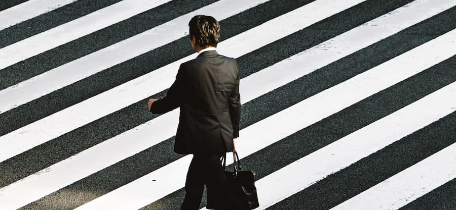 Photo d'un homme en costume traversant la route sur un passage piéton